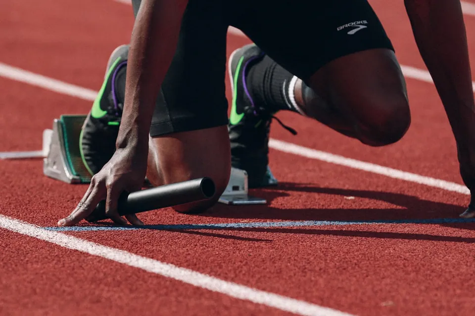 Sprinter in the blocks on a red track